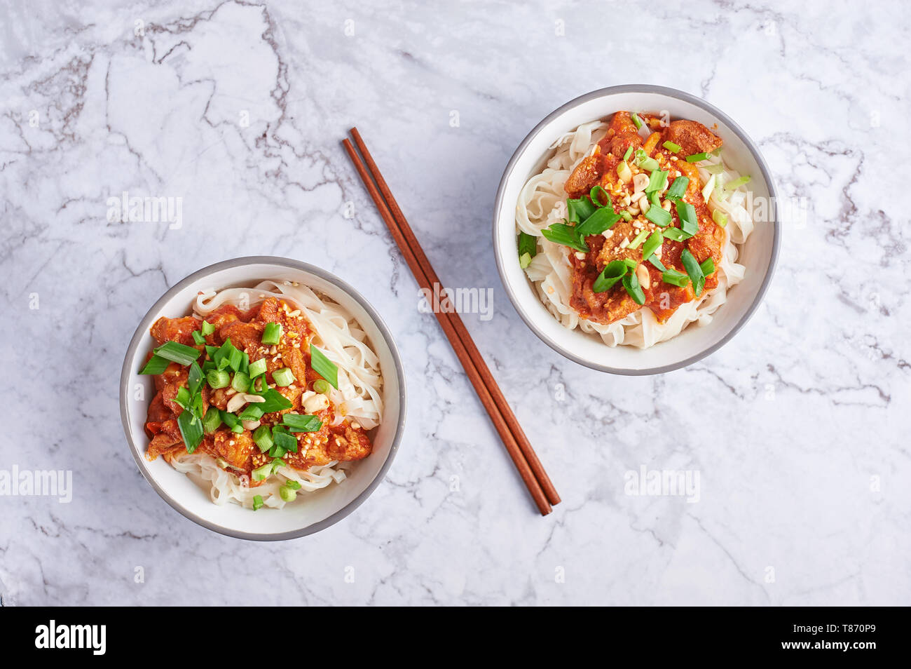 Shan tagliatelle con bacchette in marmo bianco del piano portapaziente. cucina birmana piatto tradizionale. myanmar cibo. spaghetti di riso con carne di maiale in pomodori. piatto asiatico Foto Stock