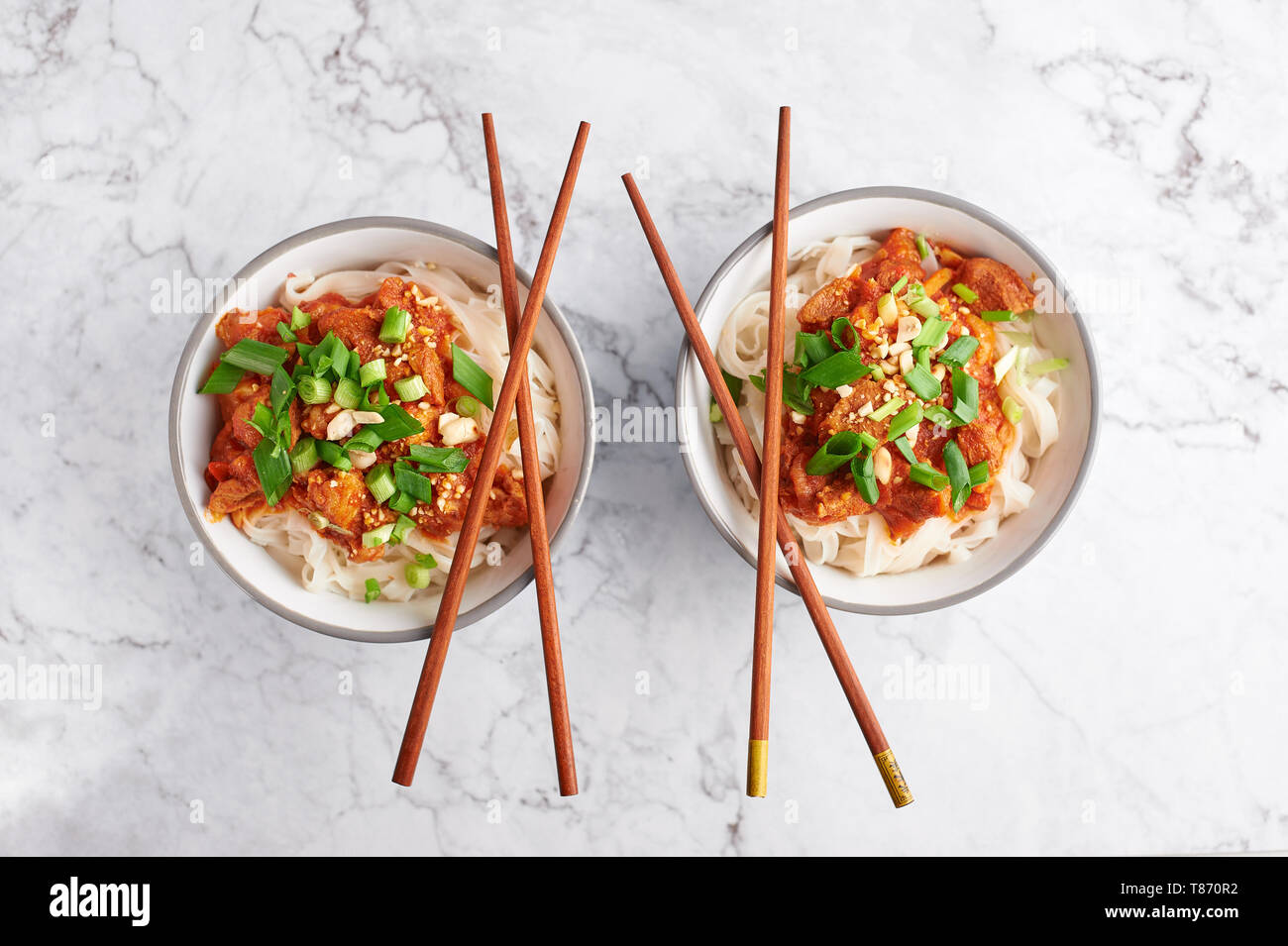 Shan tagliatelle con bacchette in marmo bianco del piano portapaziente. cucina birmana piatto tradizionale. myanmar cibo. spaghetti di riso con carne di maiale in pomodori. piatto asiatico Foto Stock