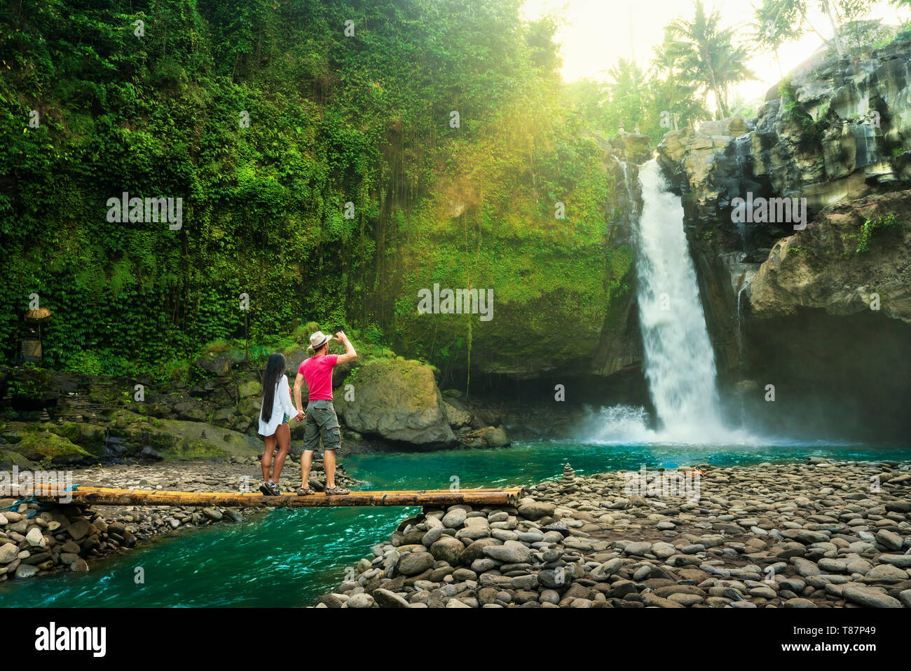 Uno stile di vita attivo giovane godere di sunrise incredibile cascata Tegenungan nascosti nella foresta pluviale tropicale Jungle Island Bali, Indonesia Foto Stock