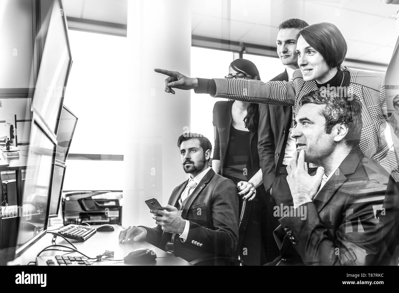Il successo del team aziendale guardando i dati commerciali su schermi di computer in ufficio aziendale. Foto Stock