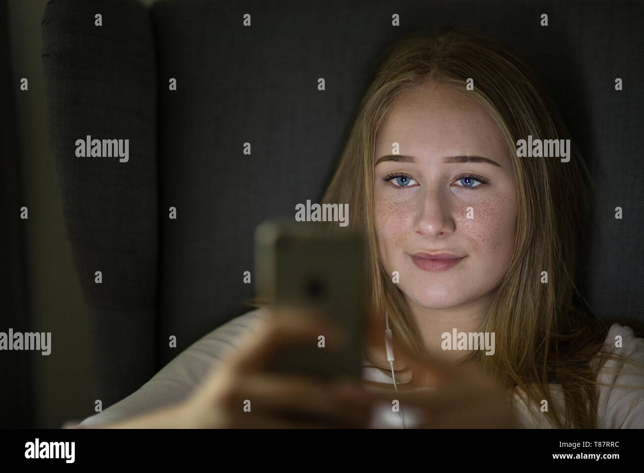 Geschminktes teeanager Mädchen mit blauen Augen spielt sono a portata di mano. Il sig. mit Foto Stock