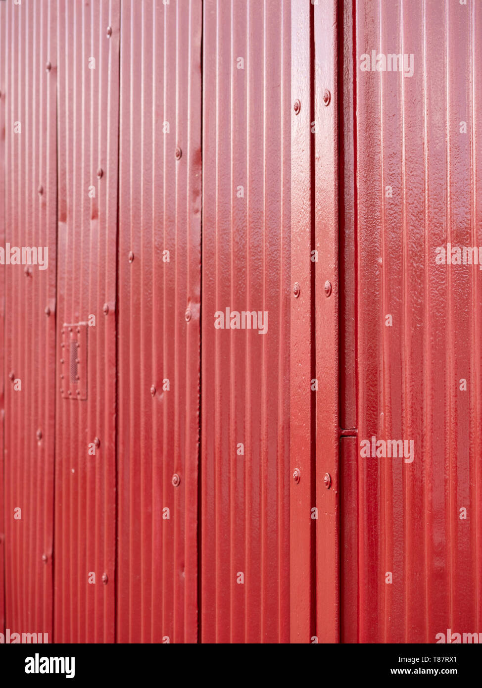 Rosso brillante porta ondulato sul magazzino al porto di Bristol, Bristol, Regno Unito. Foto Stock