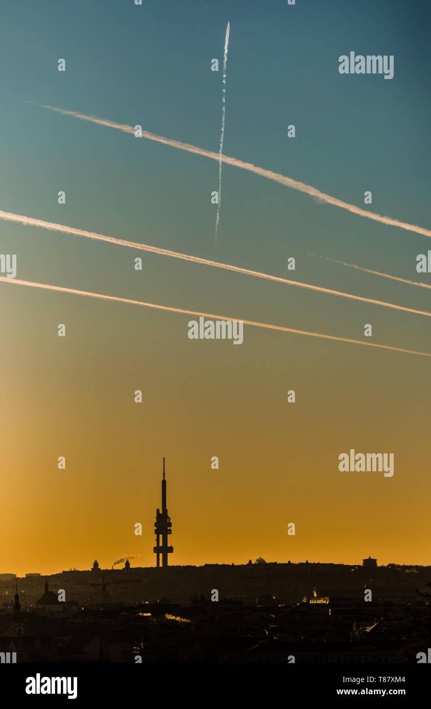 L'immagine verticale del paesaggio urbano di Praga con silhouette di Zizkov tower e orizzonte scuro durante il coloratissimo sunrise. Il giallo e il blu del cielo riempito con linee. Foto Stock