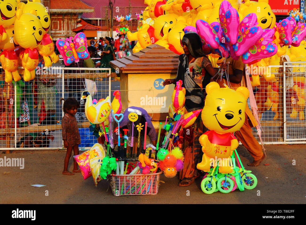 Giocattolo di strada i venditori con sorridente giocattoli per attrarre i bambini. La vita quotidiana in strada per foo. Una vista da Thrisoor pooram 2019 Foto Stock