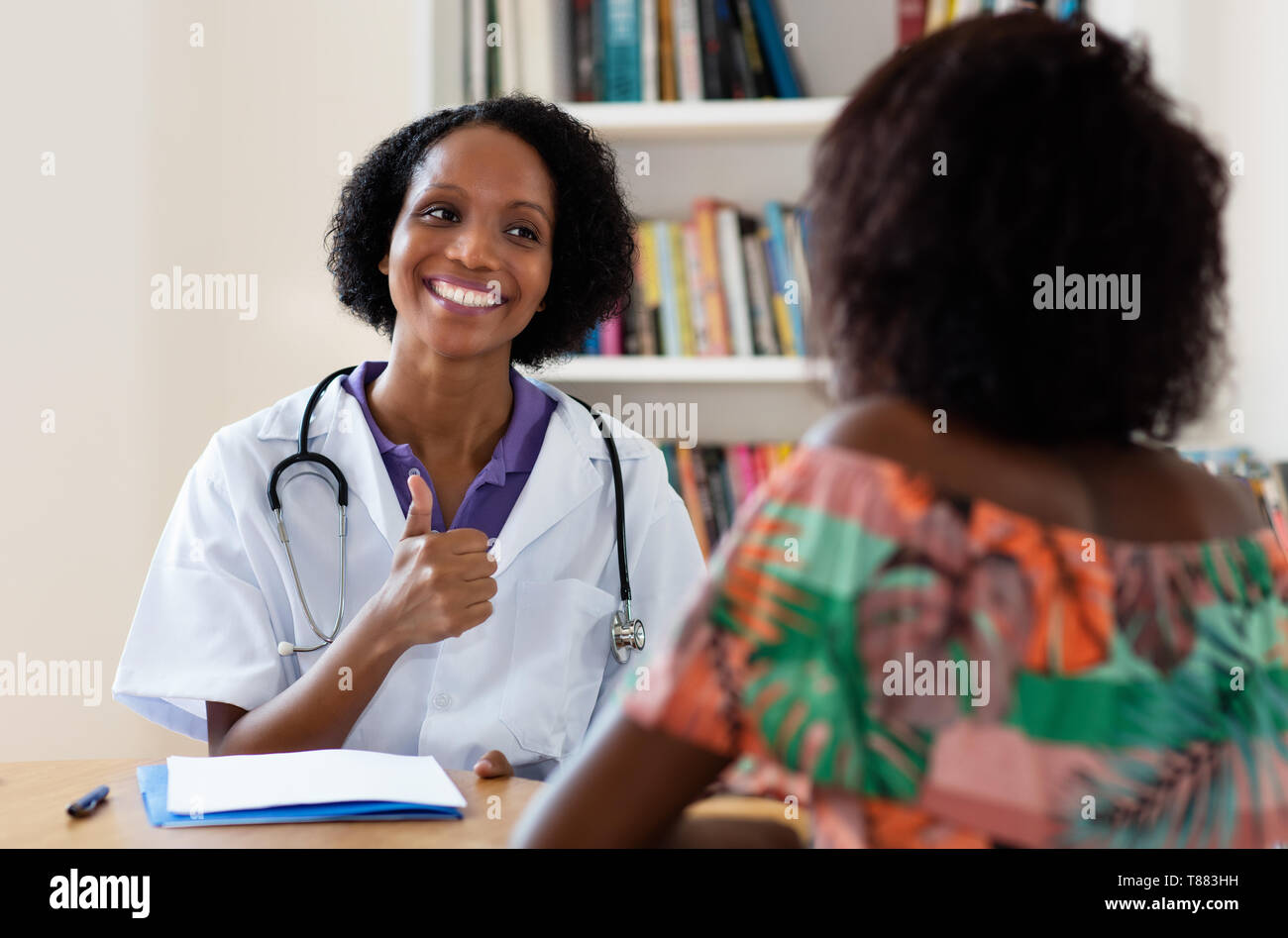 Americano africano ginecologo femmina ha buone notizie per il paziente in ospedale Foto Stock