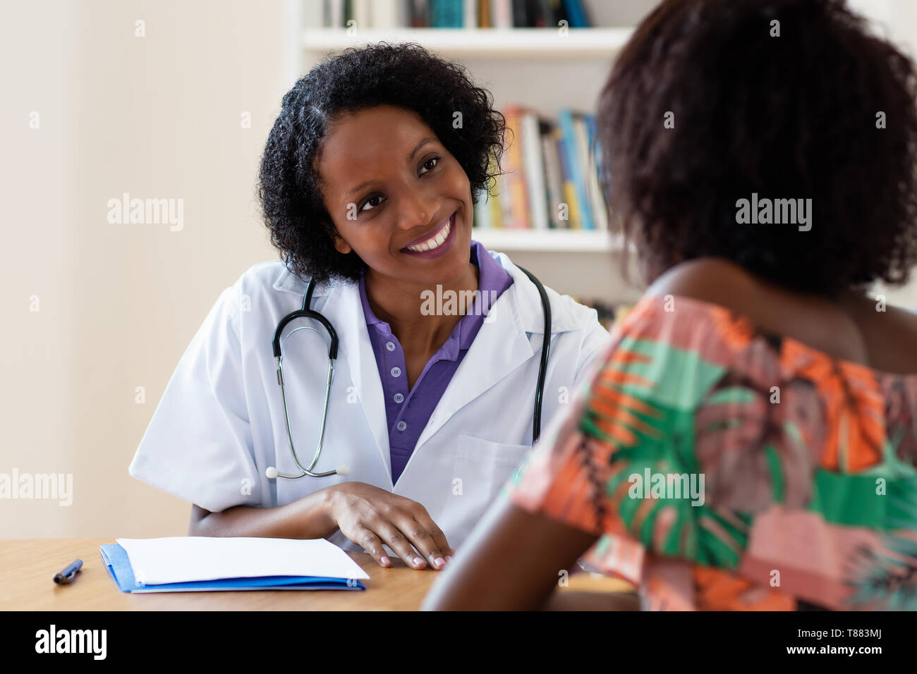 Ridendo americano africano donne medico con il paziente in ospedale Foto Stock