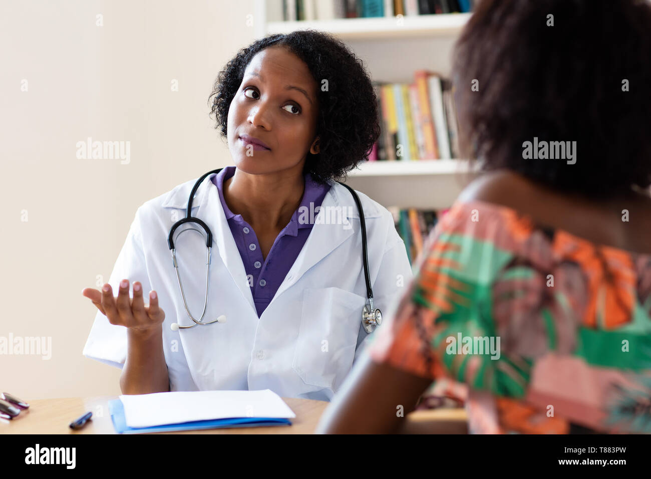 Americano africano ginecologo femmina parlando al paziente in ospedale Foto Stock