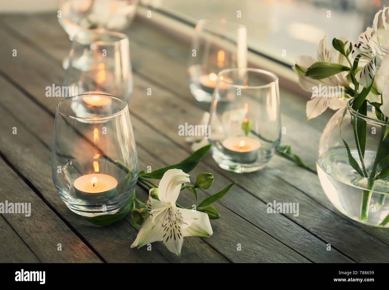 Bella candele accese in bicchieri sul davanzale di legno Foto Stock