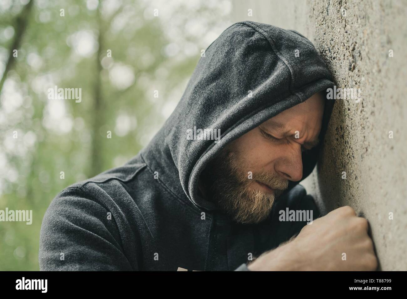Triste uomo appoggiato la sua testa contro una parete Foto Stock
