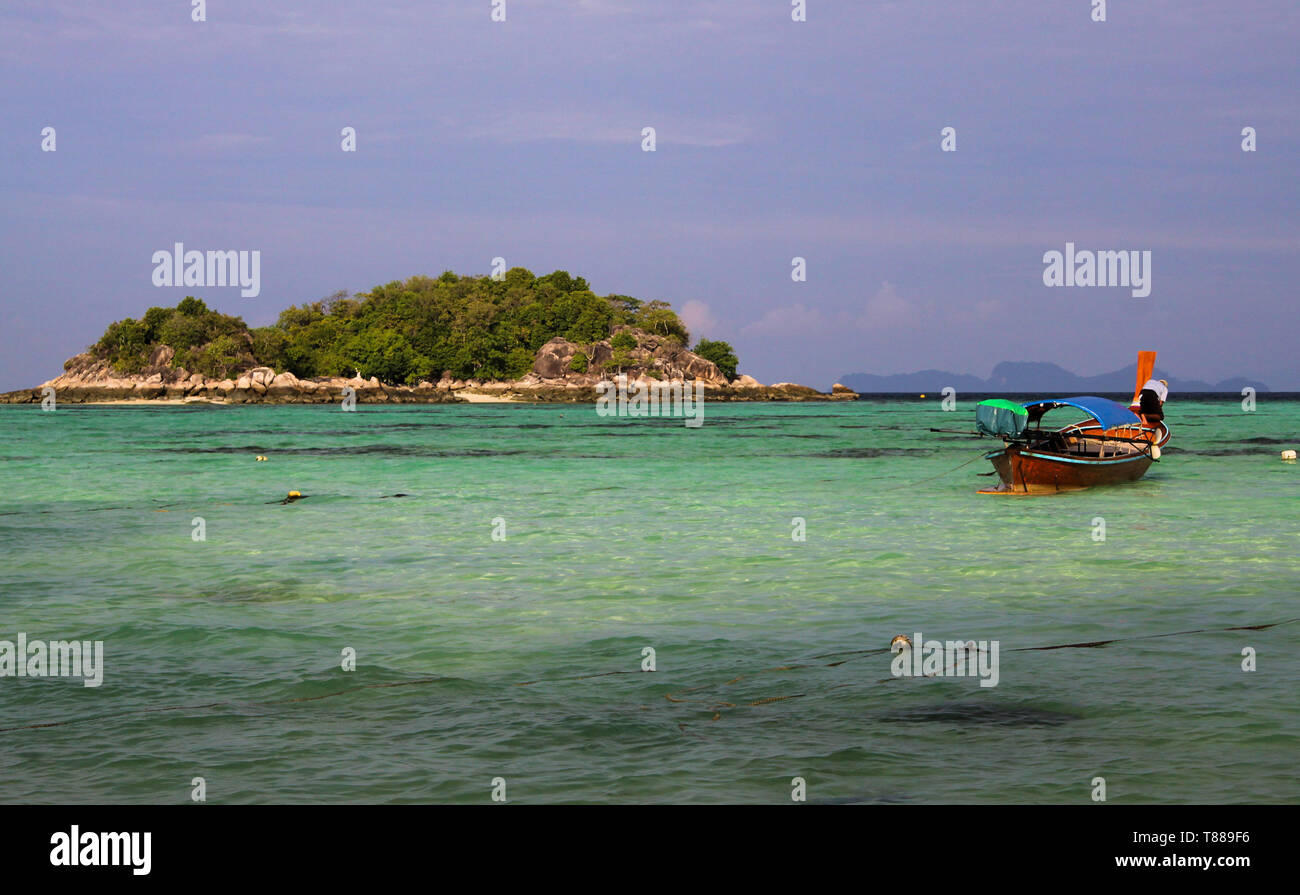 Vista sulla baia turchese in contrasto con il blu del cielo sulla piccola isola con lunga coda barche su Ko Lipe, Thailandia Foto Stock