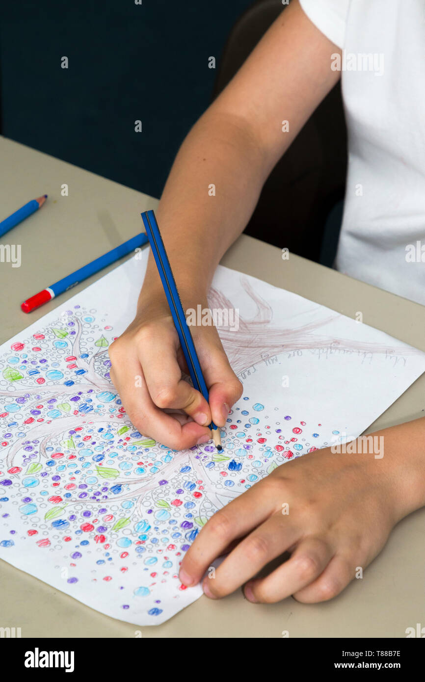 E un esempio di un bambino / kid utilizzando leggermente sbagliato / matita errata presa durante la colorazione in / pencilling a scuola. Regno Unito. La matita deve essere appoggiato sul dito medio (108) Foto Stock