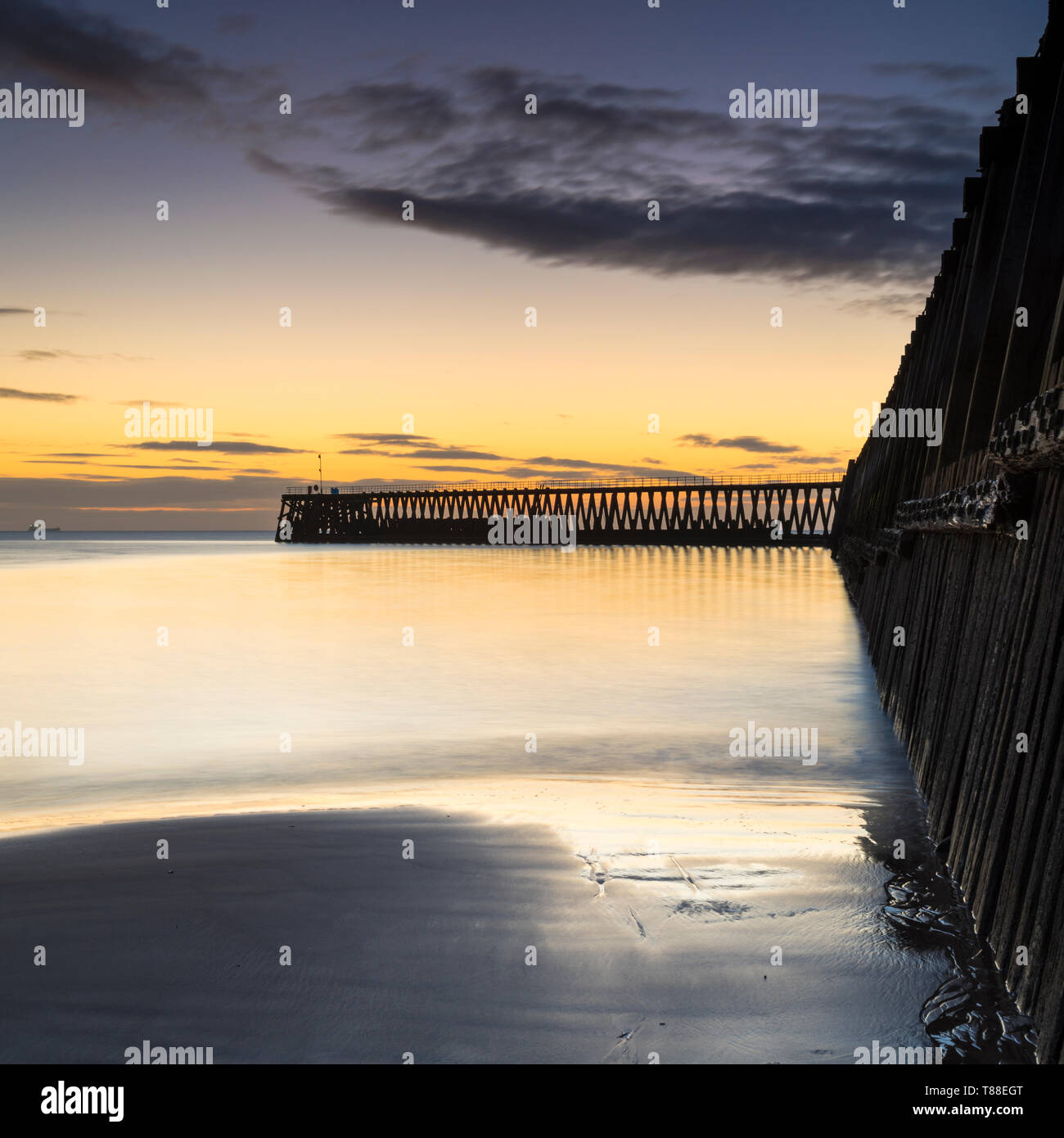 Inizio inverno freddo mattino per catturare la orange sunrise che sagome di Blyth banchine portuali & Porto Faro in Northumberland Foto Stock