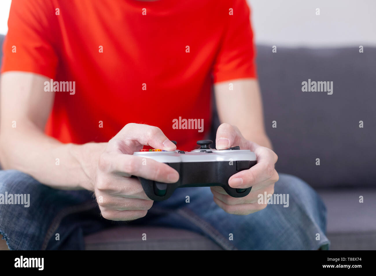 Giovane uomo riproduce il video gioco utilizzando un gamepad. Primo piano. Foto Stock