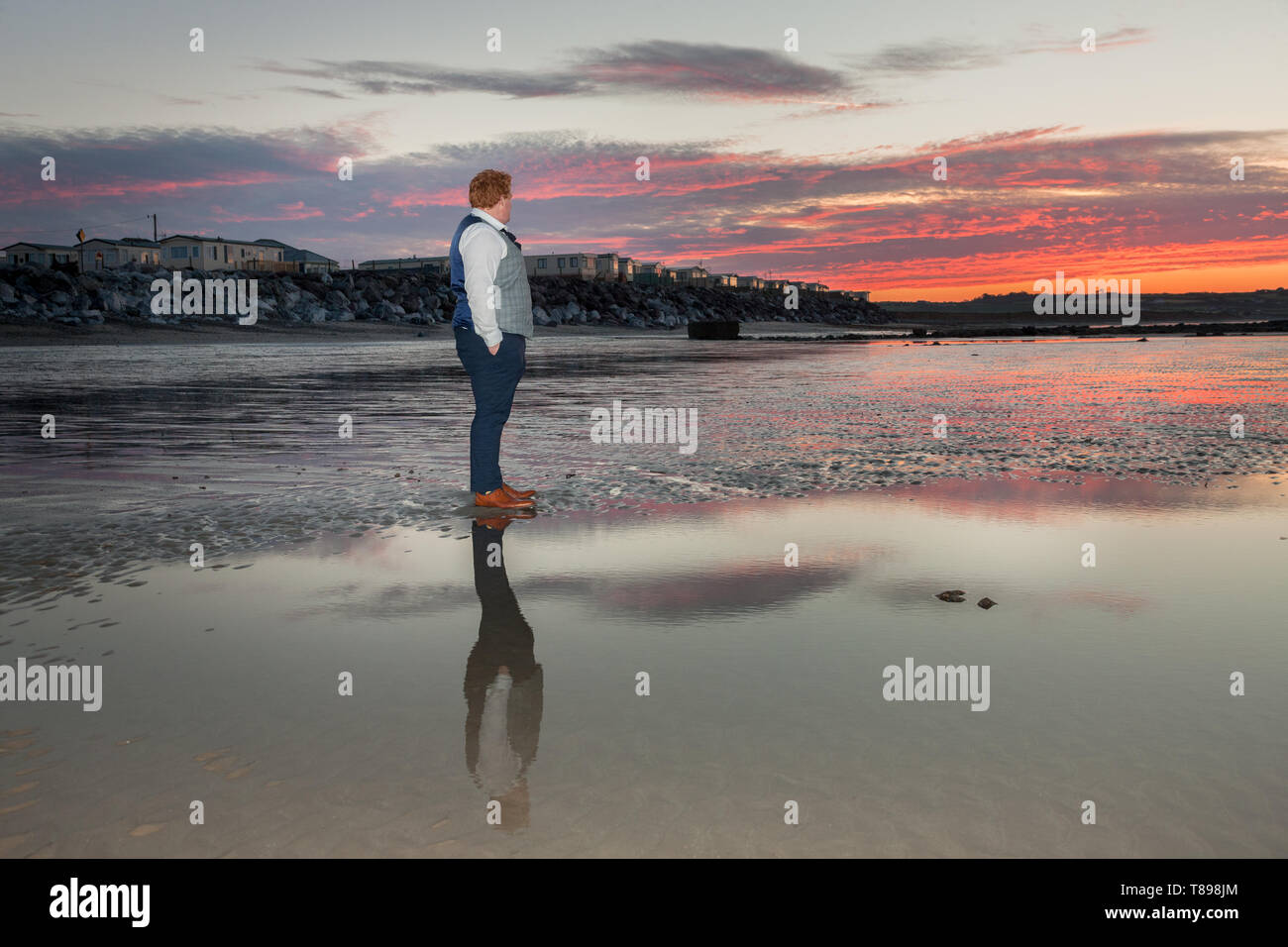 Garryvoe, Cork, Irlanda. Il 12 maggio 2019. Chris O'Regan, si prende una pausa dal suo amico del party di nozze in un hotel nelle vicinanze per catturare la gloriosa alba In Garryvoe Beach, Co. Cork, Irlanda. Credito: David Creedon/Alamy Live News Foto Stock