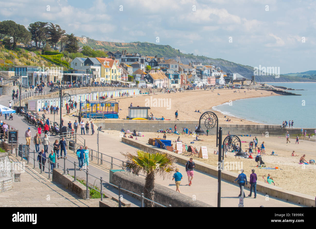 Lyme Regis, Dorset, Regno Unito. Il 12 maggio 2019. Regno Unito: Meteo visitatori e amanti di spiaggia godetevi la pittoresca spiaggia presso la località balneare di Lyme Regis su una calda e soleggiata domenica. Le temperature sono dilagano con alti di 25 gradi celsius previsioni per la prossima settimana. Credito: Celia McMahon/Alamy Live News. Foto Stock