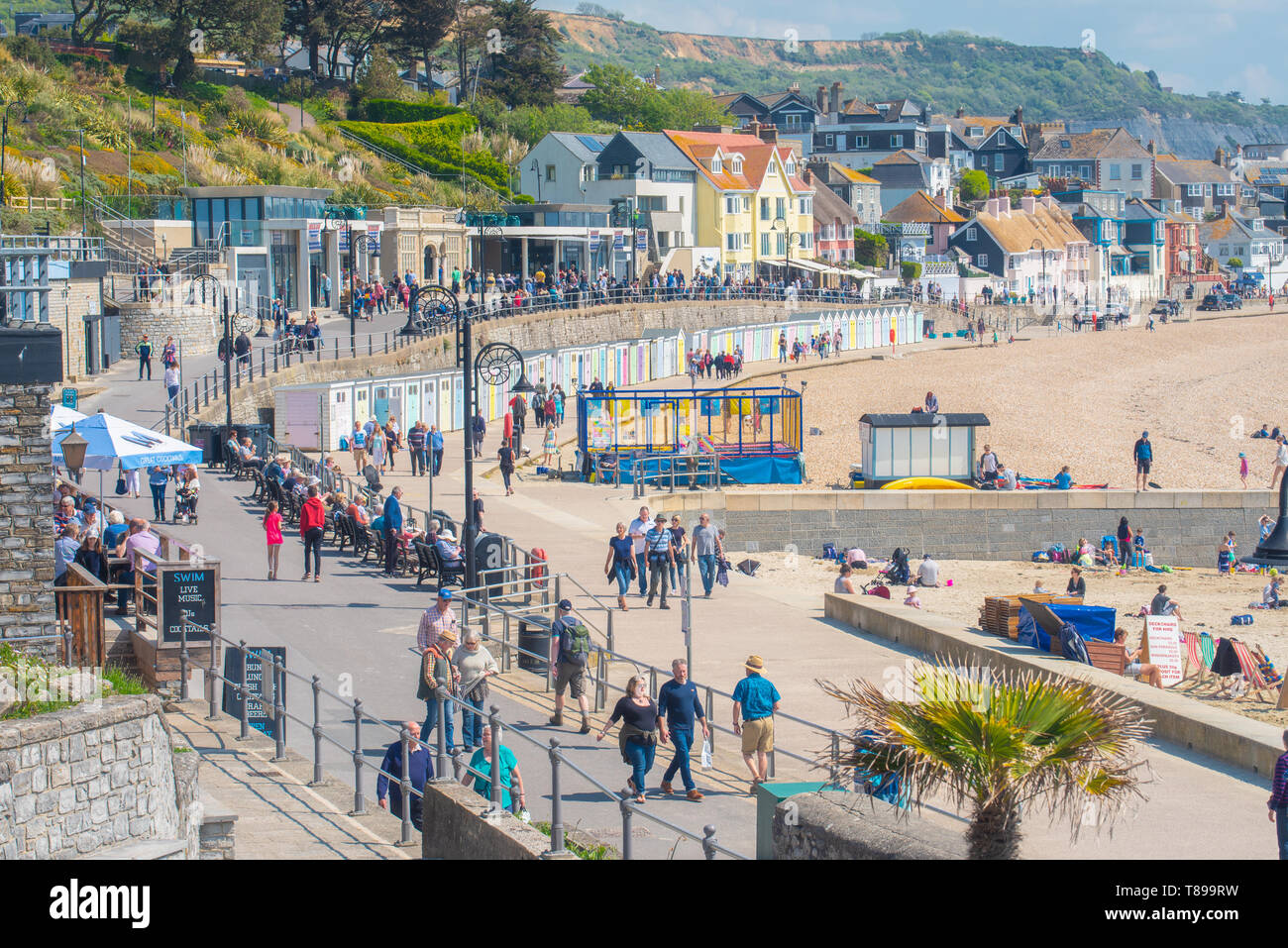Lyme Regis, Dorset, Regno Unito. Il 12 maggio 2019. Regno Unito: Meteo visitatori e amanti di spiaggia godetevi la pittoresca spiaggia presso la località balneare di Lyme Regis su una calda e soleggiata domenica. Le temperature sono dilagano con alti di 25 gradi celsius previsioni per la prossima settimana. Credito: Celia McMahon/Alamy Live News. Foto Stock