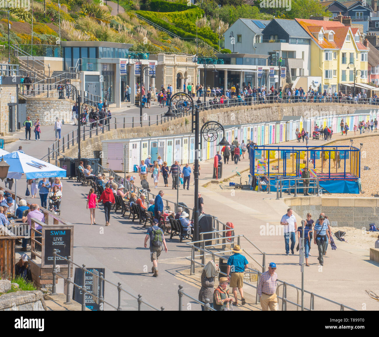 Lyme Regis, Dorset, Regno Unito. Il 12 maggio 2019. Regno Unito: Meteo visitatori e amanti di spiaggia godetevi la pittoresca spiaggia presso la località balneare di Lyme Regis su una calda e soleggiata domenica. Le temperature sono dilagano con alti di 25 gradi celsius previsioni per la prossima settimana. Credito: Celia McMahon/Alamy Live News. Foto Stock