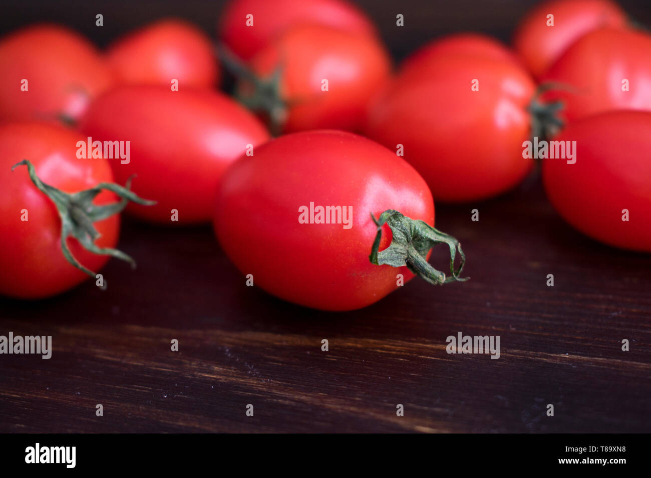 Pomodori uva al buio su un sfondo di legno Foto Stock