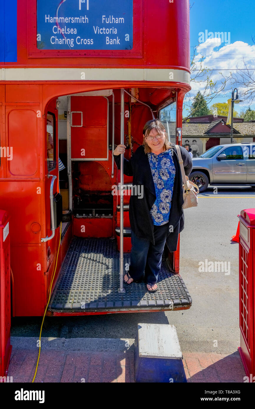 Donna sul ponte del bus rosso a due piani. Foto Stock