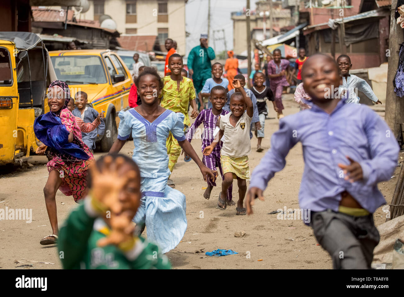 I bambini in esecuzione giù per una strada a Lagos, Nigeria. Foto Stock