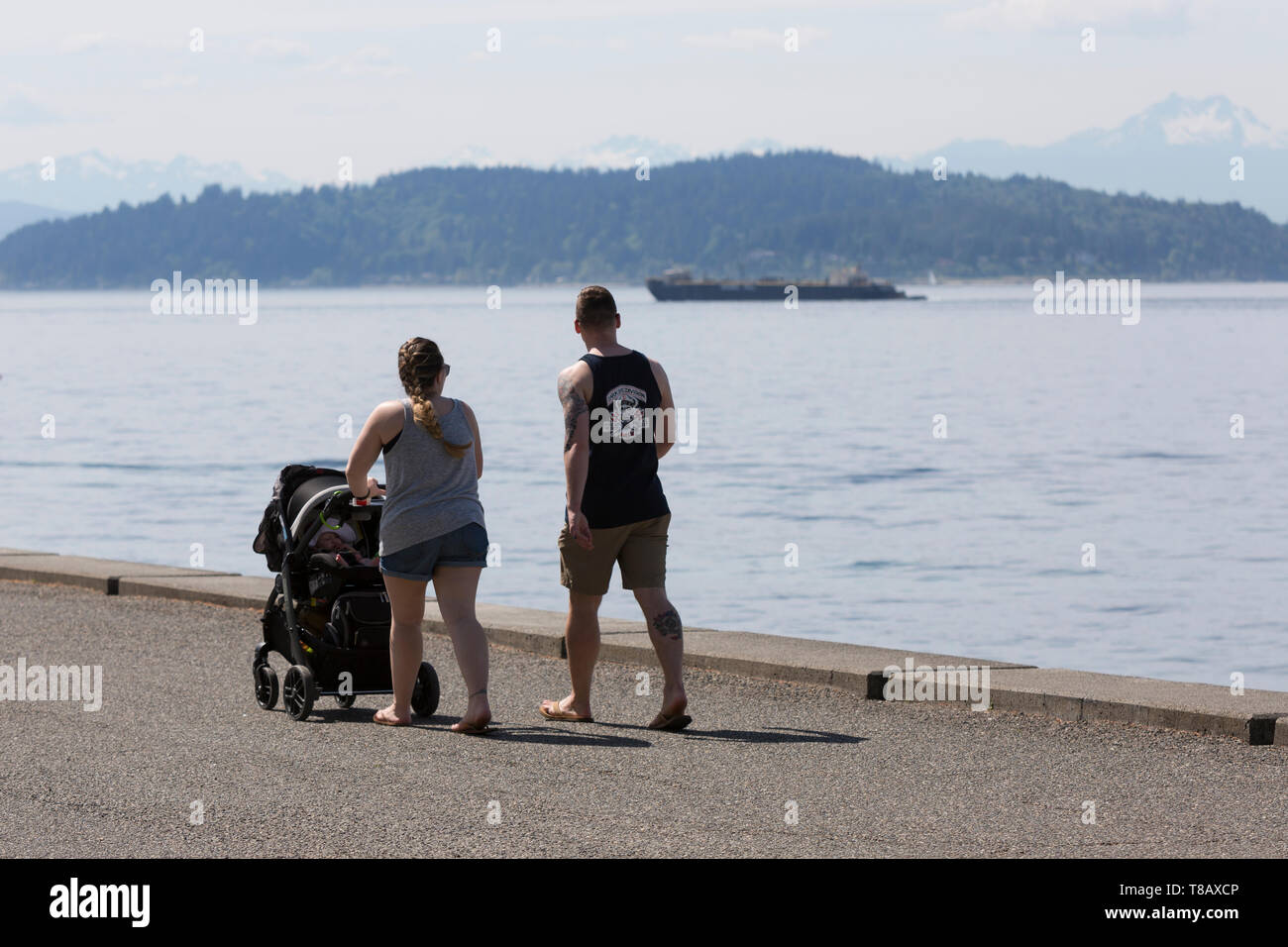 Seattle, Washington: una giovane coppia passeggiate lungo il sentiero Alki in West Seattle come la città si affaccia record di calore per il secondo giorno consecutivo. Foto Stock