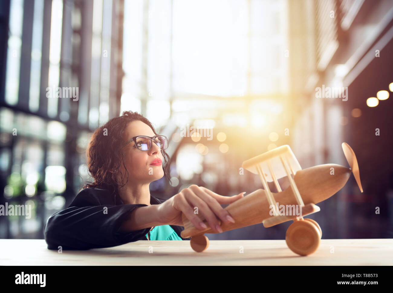 Imprenditrice giocare con un giocattolo aereo. Concetto di azienda startup e il successo aziendale. Foto Stock