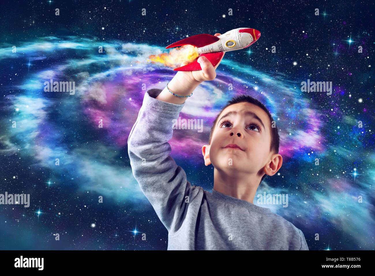 Bambino gioca con un razzo. Concetto di fantasia Foto Stock