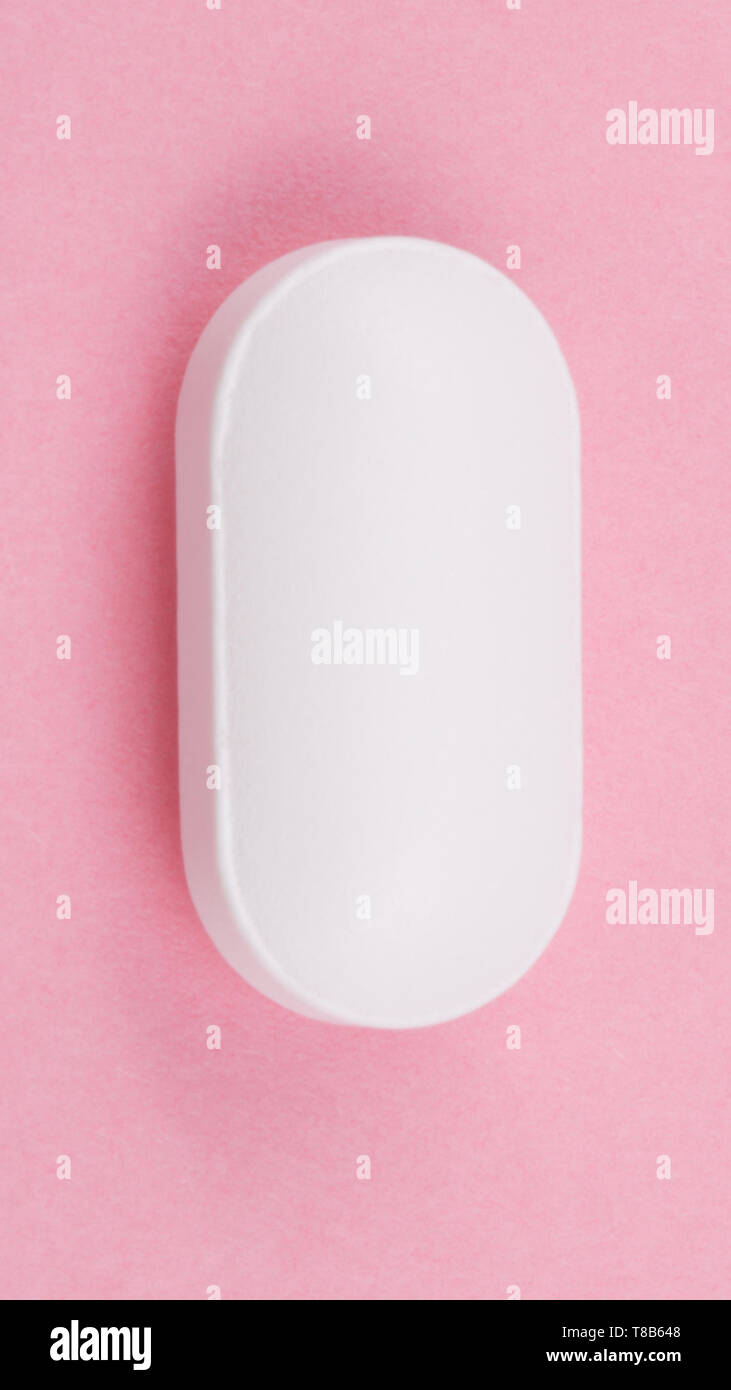 Pillola bianco su sfondo rosa Foto Stock