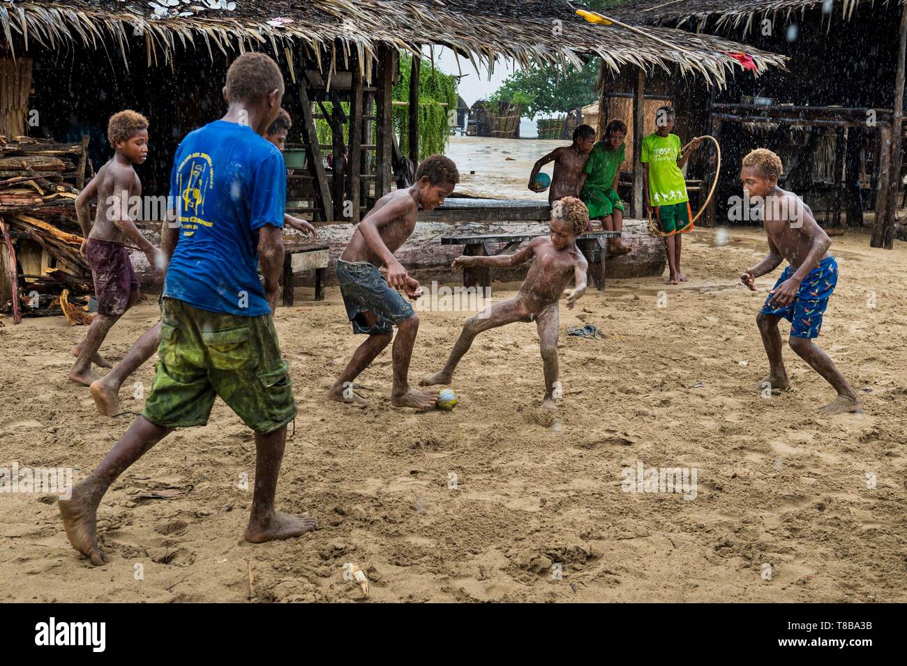 Papua Nuova Guinea, Nuova Bretagna isola, West New Britain provincia, distretto Talasea, Kimbe area, Kapò isola, bambini che giocano sotto la pioggia Foto Stock