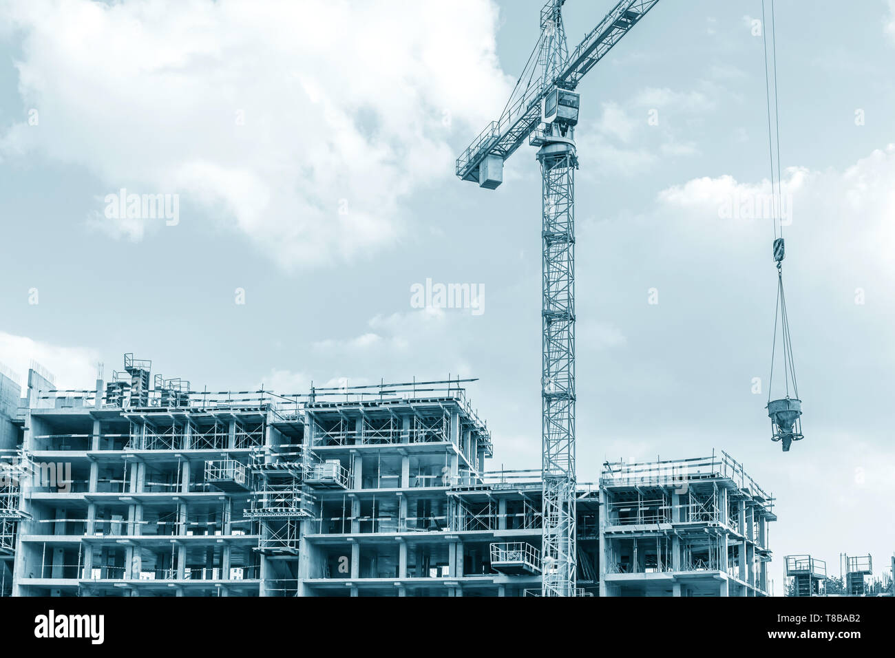 Città Sito in costruzione la costruzione di nuovi appartamenti. gru a torre sul cielo blu sullo sfondo Foto Stock