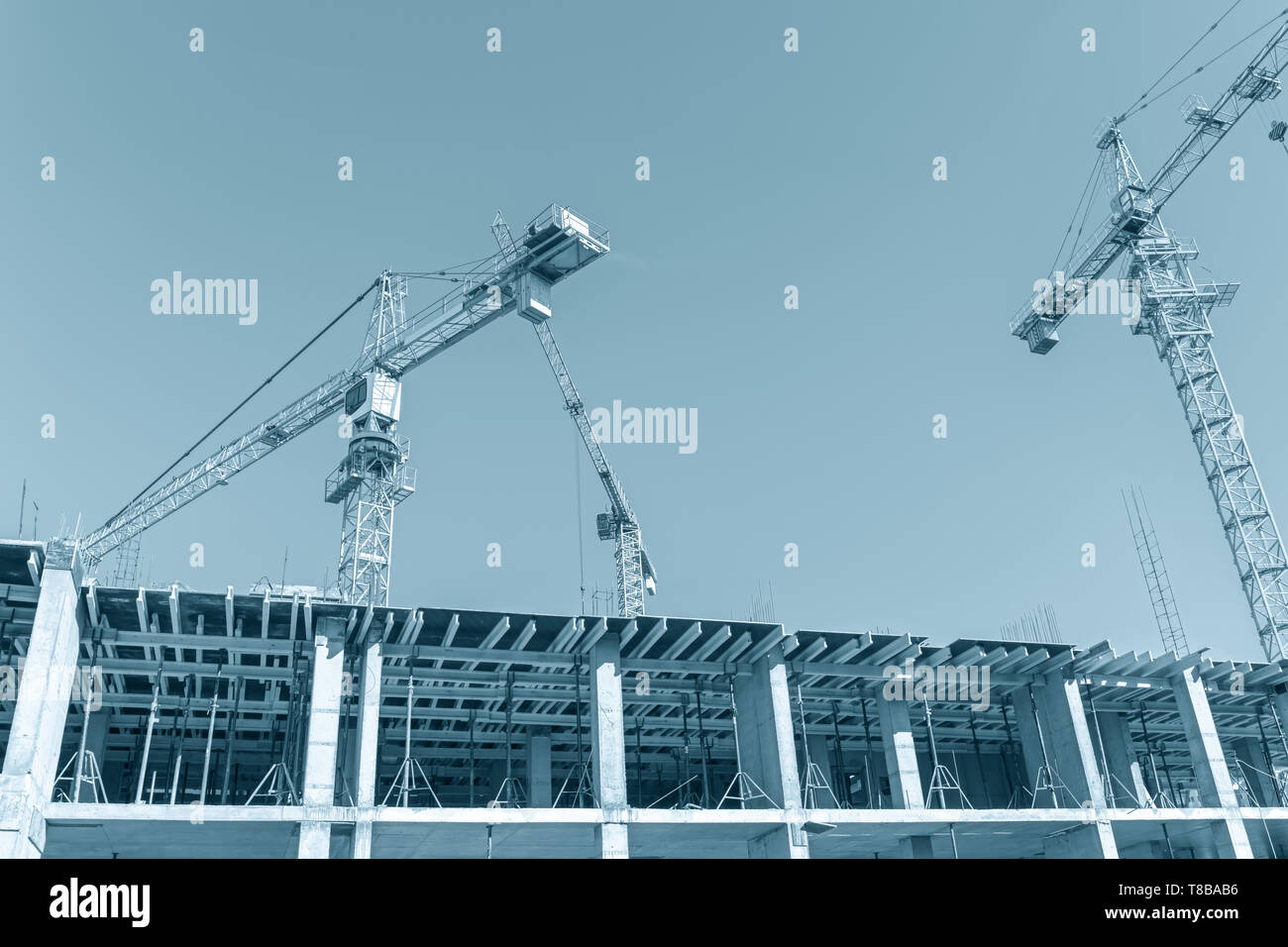 Costruzione della città sito. gru per edilizia contro il cielo blu sullo sfondo. urbano lo sviluppo di infrastruttura Foto Stock