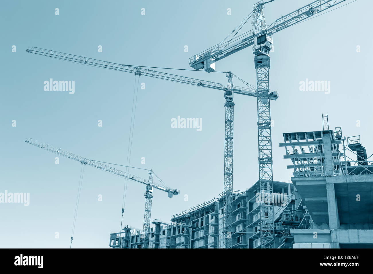 Costruzione della città sito. costruzione di gru a torre in lavoro. cielo blu sullo sfondo Foto Stock