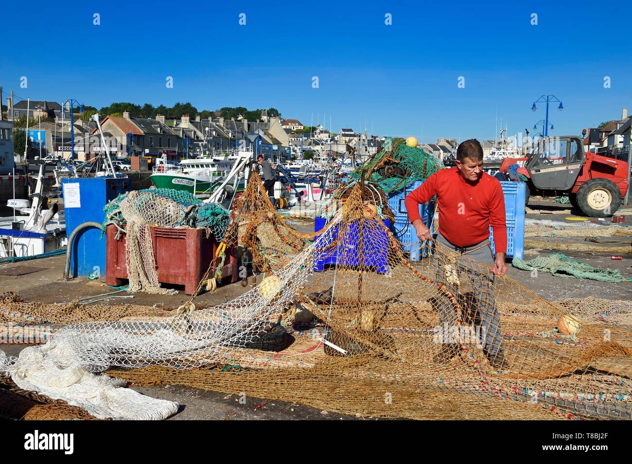 Francia, Calvados, Cote de Nacre, Port en bessin, il porto di pesca, fisherman riparazione di reti da pesca Foto Stock