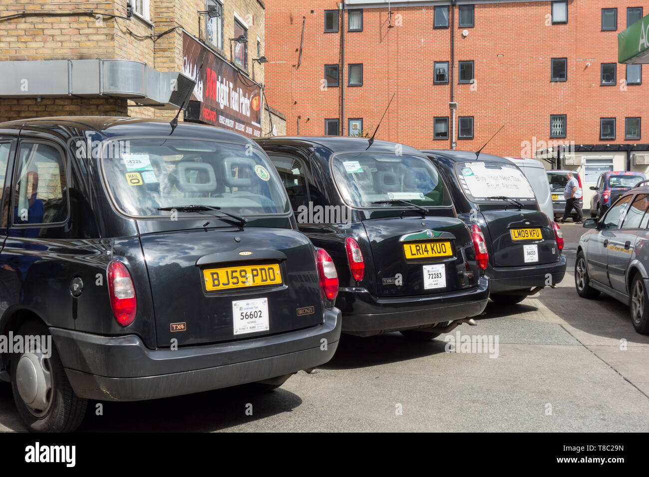 Una fila di Londra taxicabs nero in un garage a Southwark, Londra, Regno Unito Foto Stock