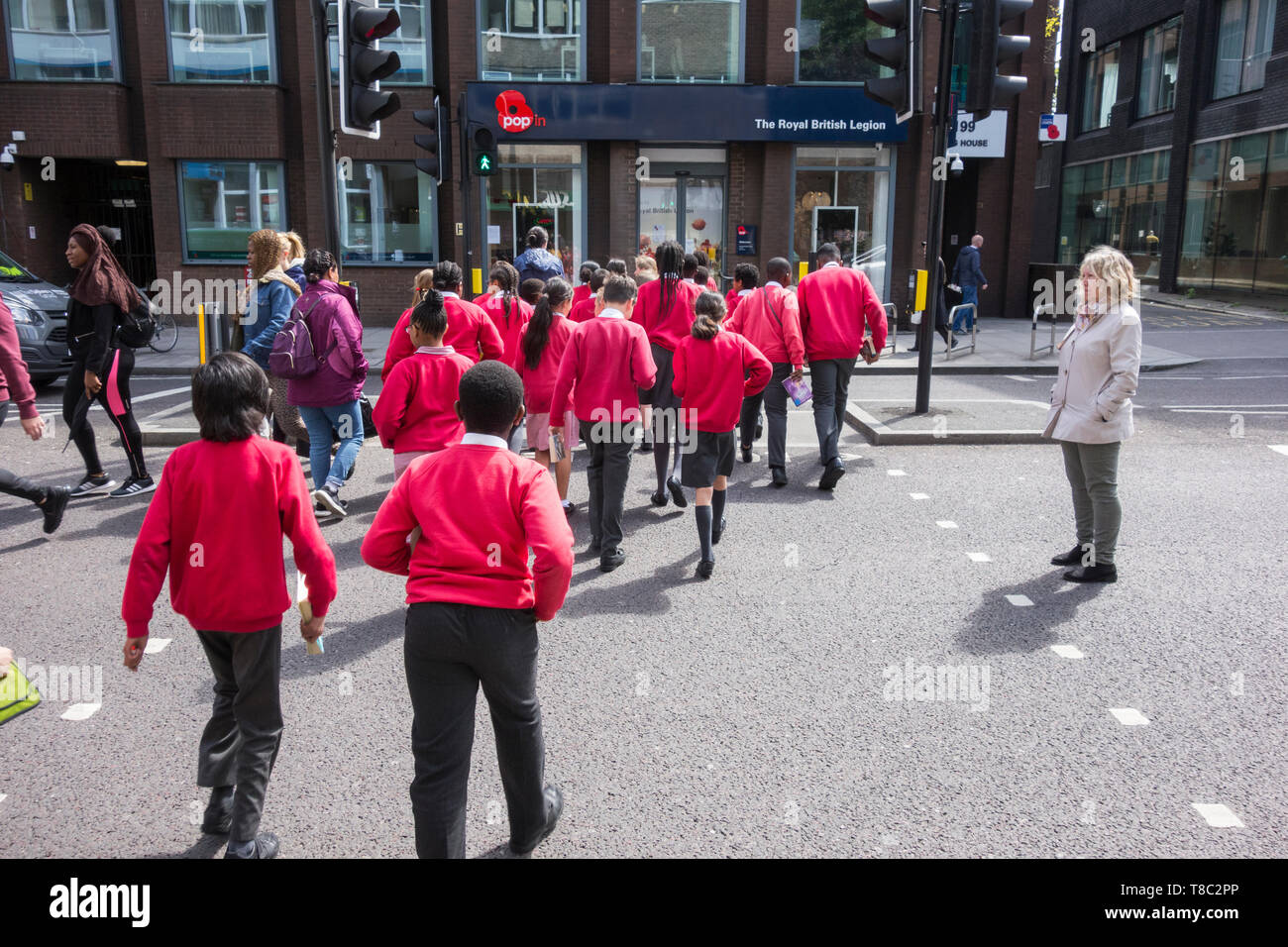Scolaresche che attraversano Borough High Street a Southwark, Londra, SE1, Inghilterra, Regno Unito Foto Stock