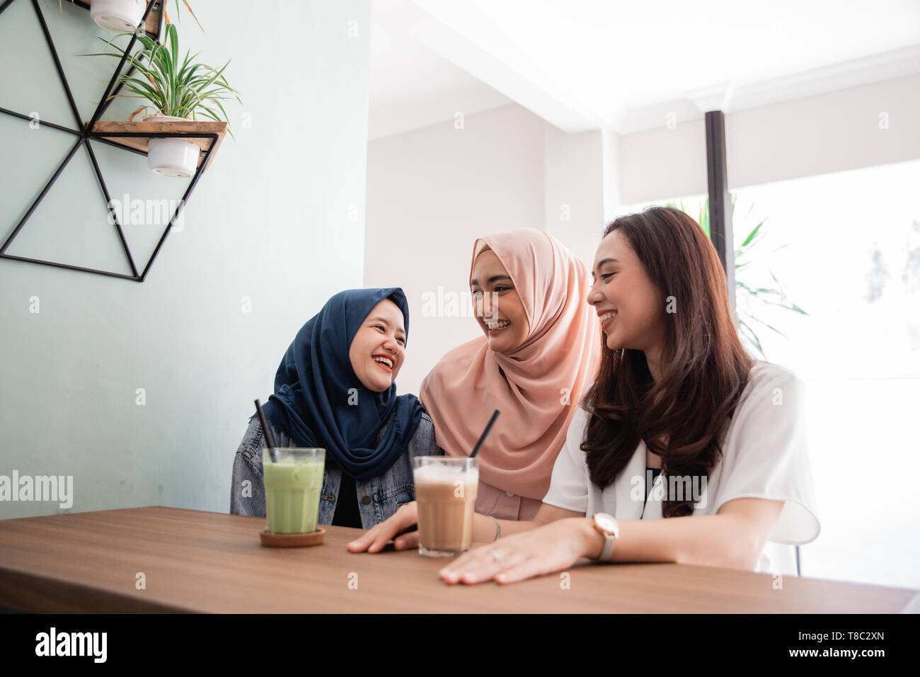 Asian donna musulmana migliori amici insieme in cafe Foto Stock