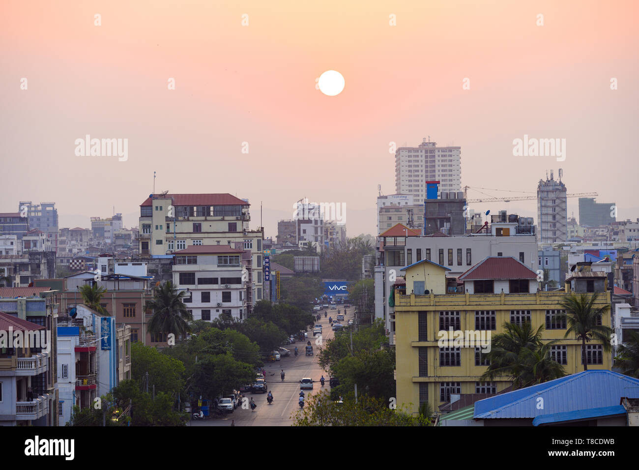 Il traffico giornaliero e la vita della città su strade trafficate di Mandalay durante il tramonto. Foto Stock
