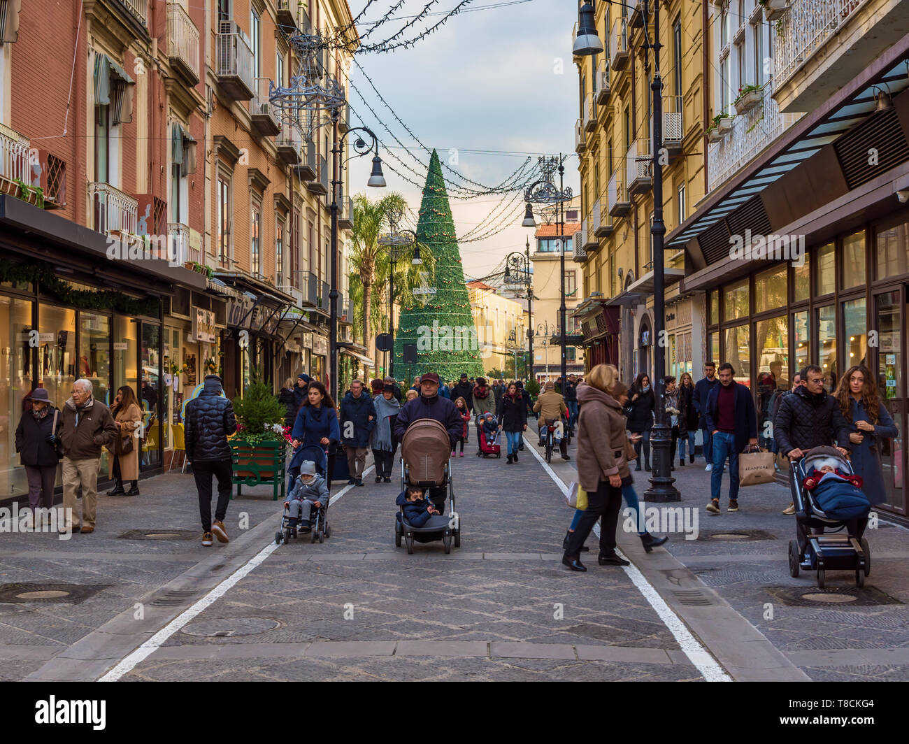 Folle di acquirenti passano davanti alle decorazioni natalizie su Corso Italia durante la stagione invernale del Natale a Sorrento, Italia Foto Stock