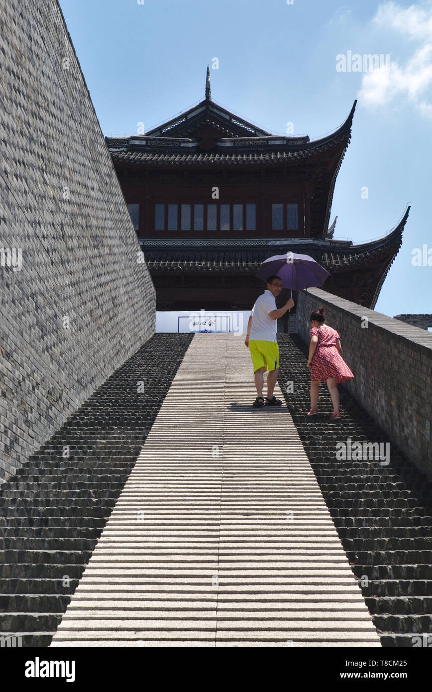 Padre e figlia salendo le scale sulla parete della città di Suzhou durante una giornata di sole Foto Stock
