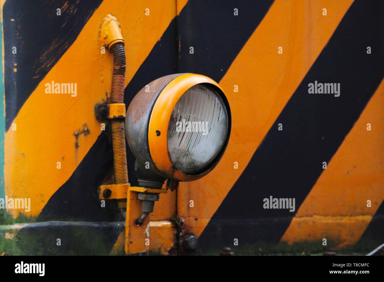 Landschaftspark Duisburg, Germania: ravvicinata di una lampada elettrica di una vecchia locomotiva di colore giallo e con strisce nere Foto Stock