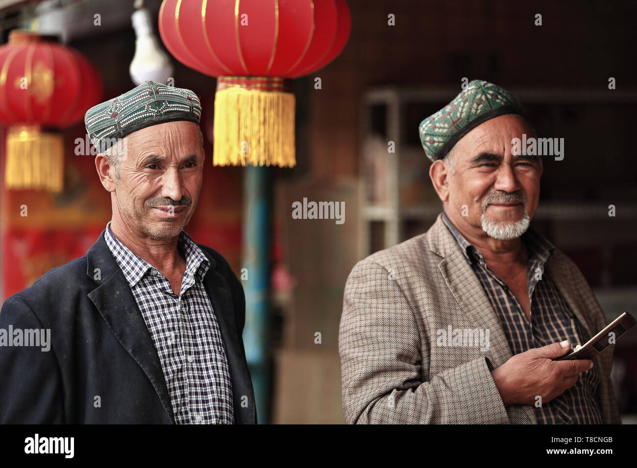 Uyghur uomini anziani che interagiscono con le nuove tecnologie-telefono cellulare. Hotan-Xinjiang-Cina-0134 Foto Stock