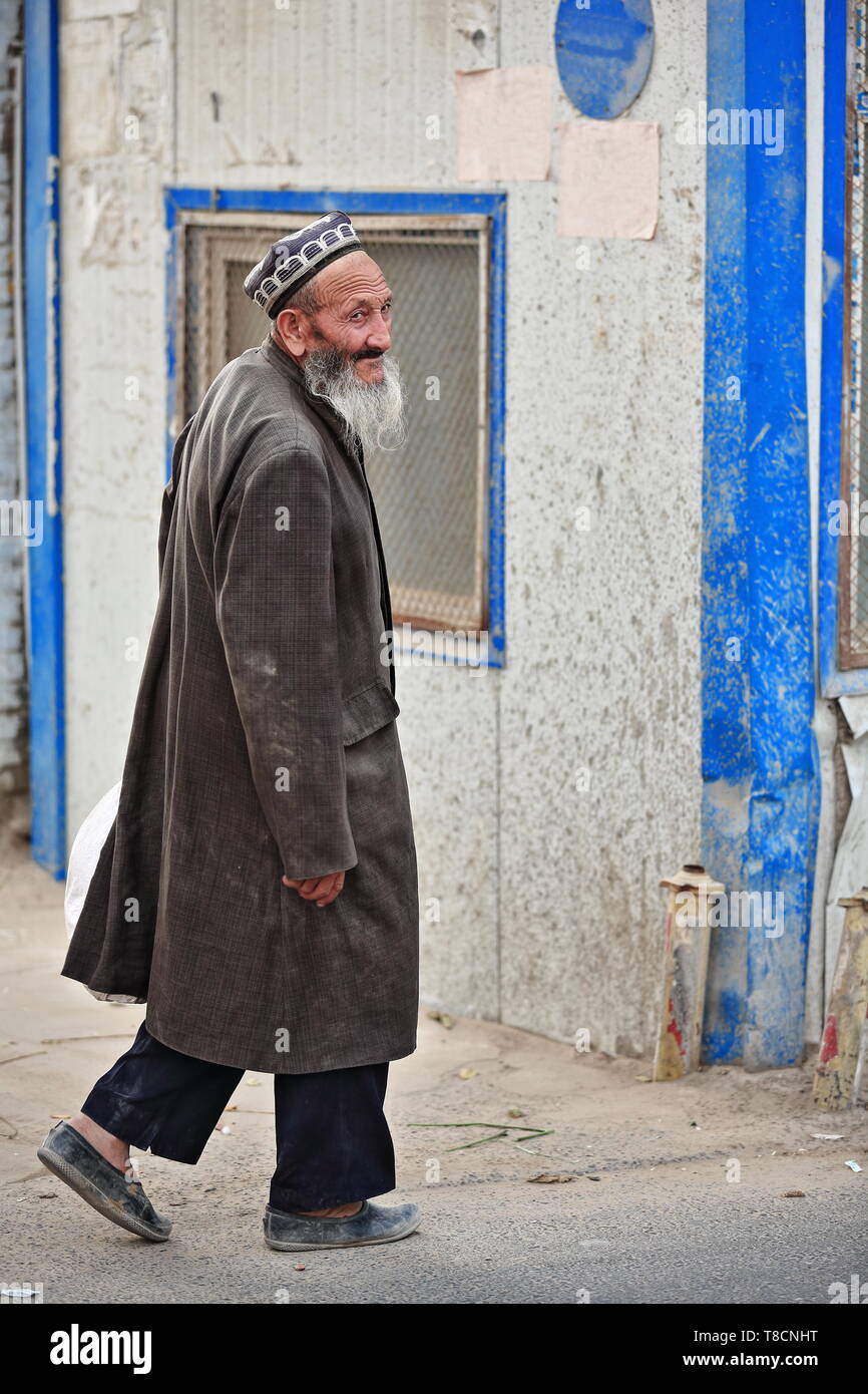 Side guardando vecchio uomo del popolo Uyghur-Domenica zona mercato-Hotan-Xinjiang-Cina-0136 Foto Stock