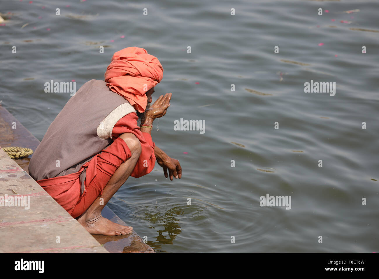 Il vecchio uomo seduto sui gradini in Pushkar Foto Stock