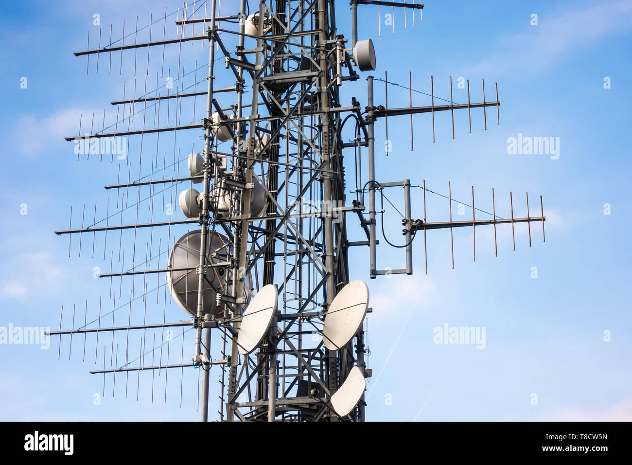 Montante di telecomunicazione antenne TV della tecnologia wireless con cielo blu al mattino Foto Stock