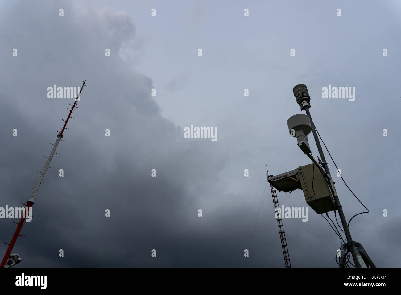 Stazione meteorologica automatica portatile all'aeroporto di Ngurah Rai sotto le spaventose nuvole scure di Cumulonimbus. Questo strumento ha la funzione di misurare la meteorologia Foto Stock