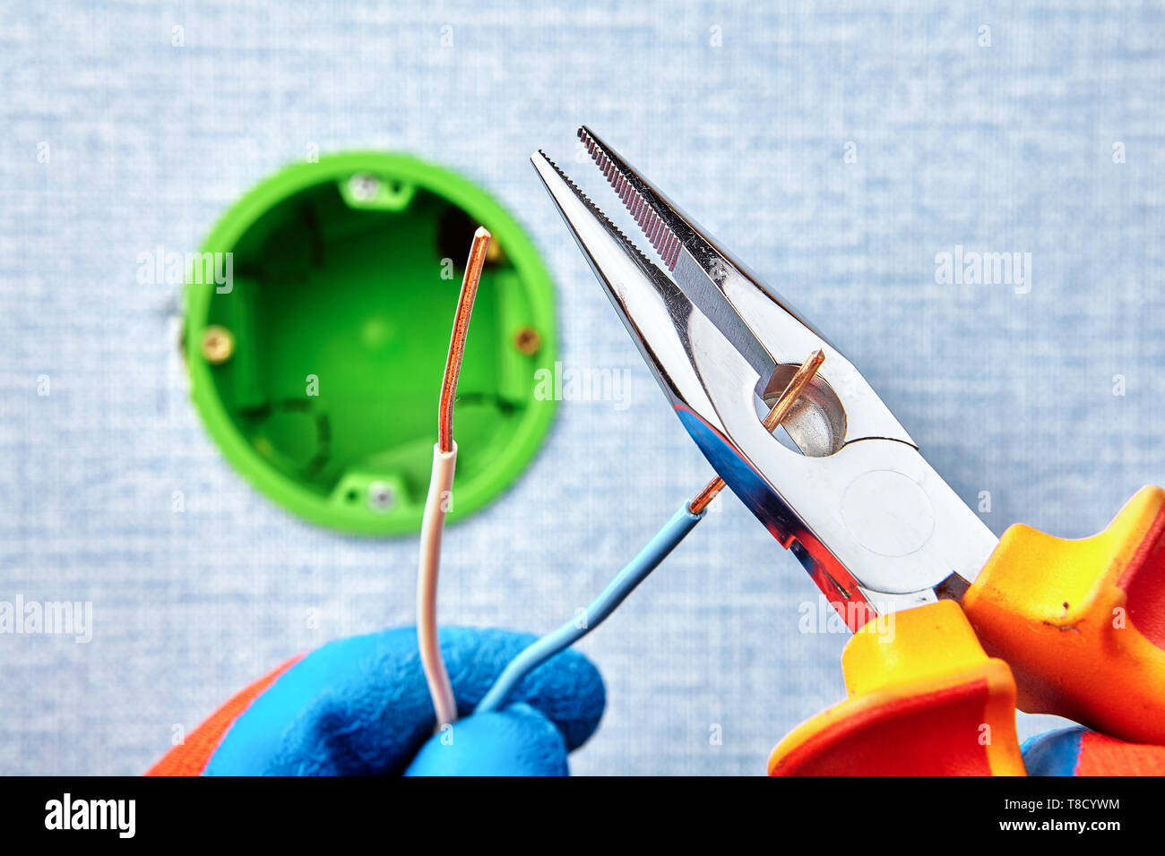 Lavoratore è il taglio di cavi in rame con pinze a becchi lunghi durante il round di montaggio della scatola elettrica, lavori elettrici. Foto Stock