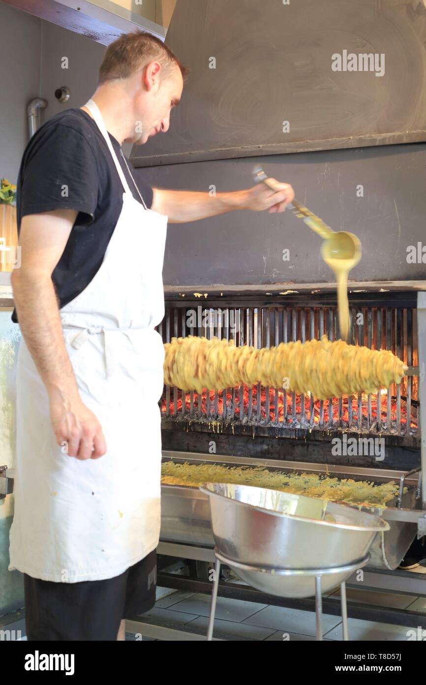 Francia, Hautes Pirenei, Aure Valle, Ancizan, Shop storie di dolci, la realizzazione di una torta allo spiedo cotta su un fuoco di legno Foto Stock
