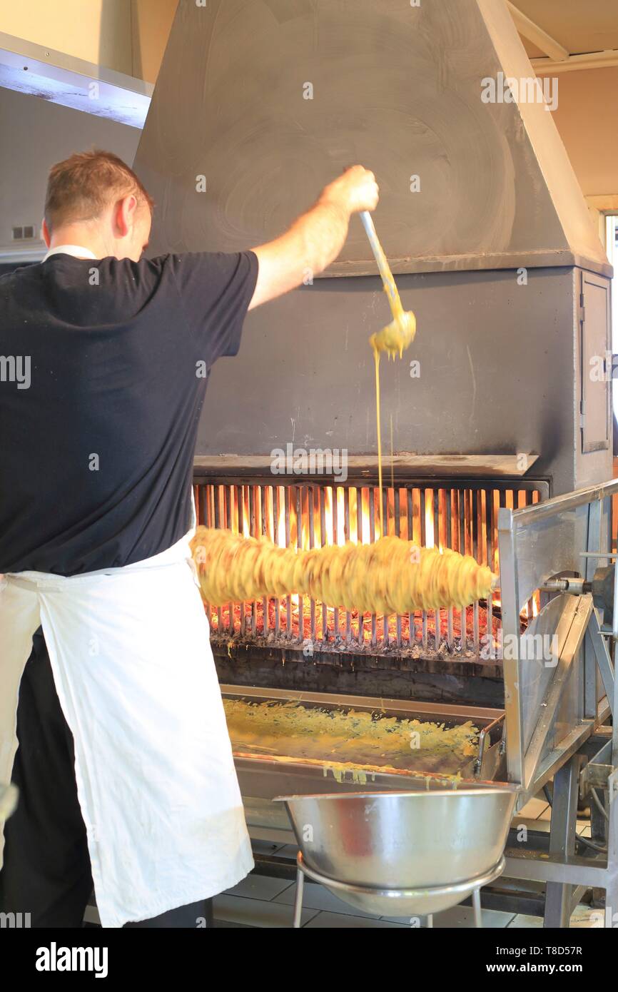 Francia, Hautes Pirenei, Aure Valle, Ancizan, Shop storie di dolci, la realizzazione di una torta allo spiedo cotta su un fuoco di legno Foto Stock