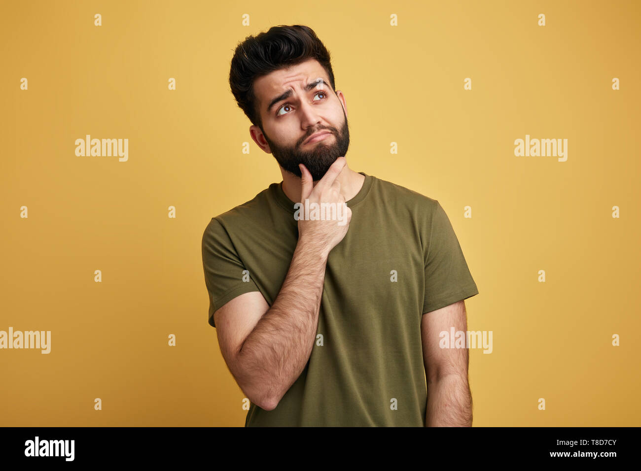 Soluzione del problema. giovane uomo carino dispone di un problema, uono. guarda in alto, costituisce un'idea isolati a sfondo giallo Foto Stock