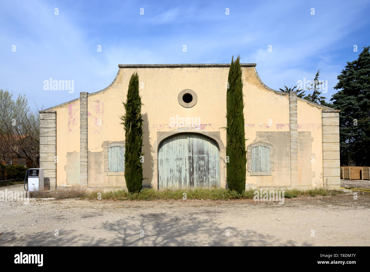 La vecchia porta incorniciata da due cipressi di una vecchia cantina o magazzino Edificio vicino Menerbes Luberon Provence Francia Foto Stock